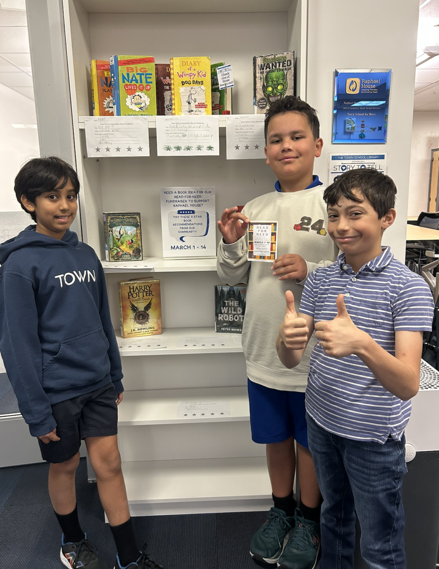 Three boys with a thumbs up in front of a bookshelf